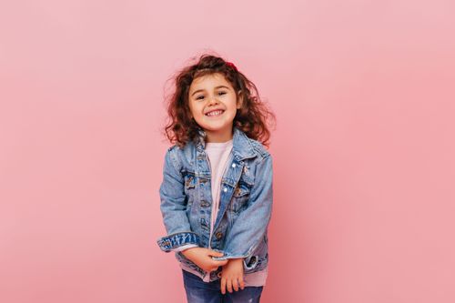 joyful-preteen-kid-with-curly-hair-laughing-camera-studio-shot-carefree-little-girl-isolated-pink-background.jpg